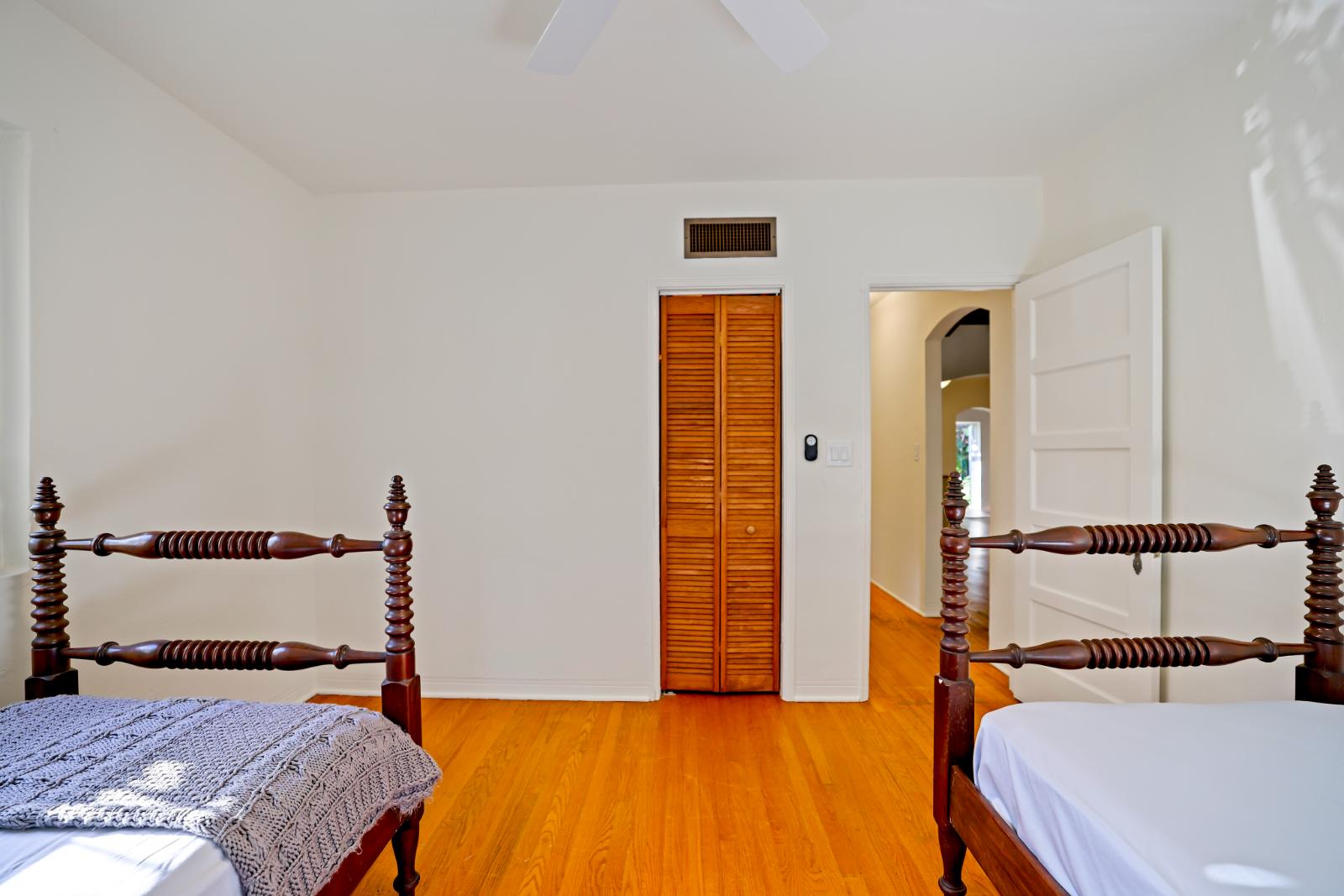 Secondary bedroom alternate angle showing hardwood floors and bright walls