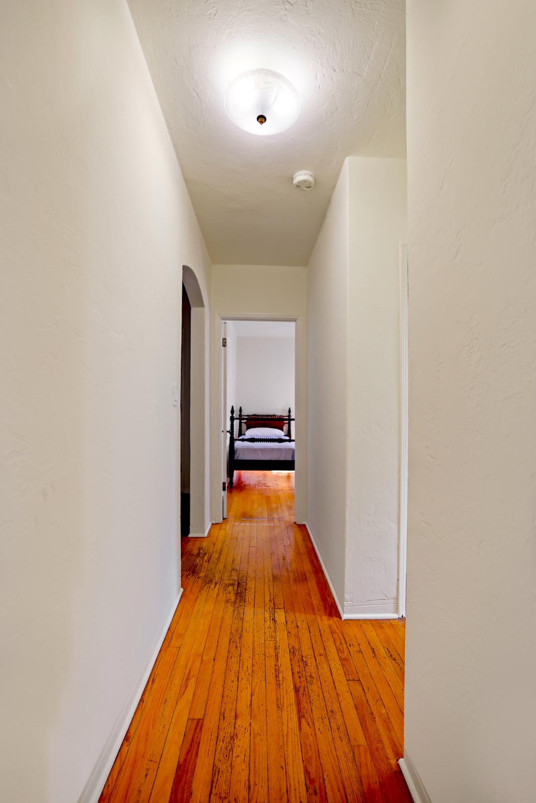 Hallway perspective highlighting transition between living spaces and bedrooms