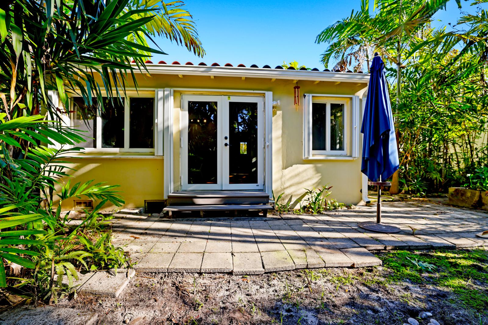 Rear exterior of the home framed by lush tropical landscaping
